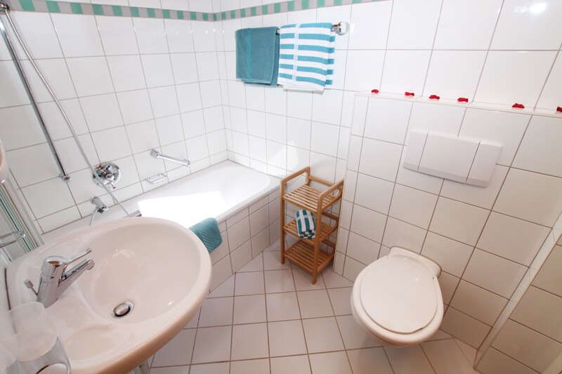 Bathroom with bathtub and WC in room 4 in the Astrid holiday home in Serfaus